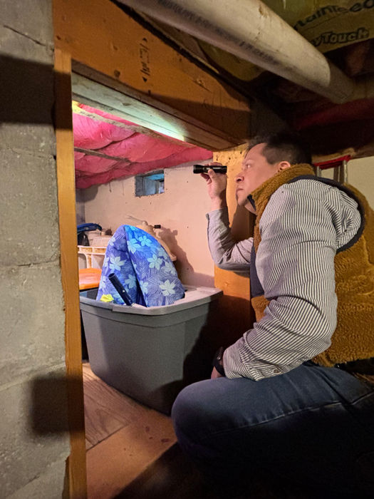 Man inspecting a cramped crawl space