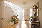 Bright home entryway with wooden floors and pink front door