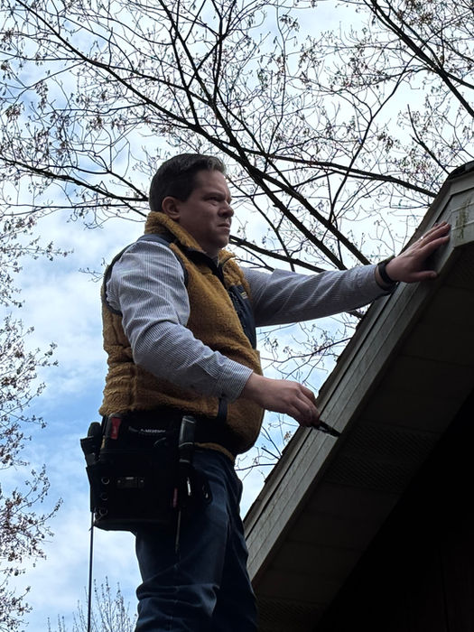 Worker inspecting a roof gutter