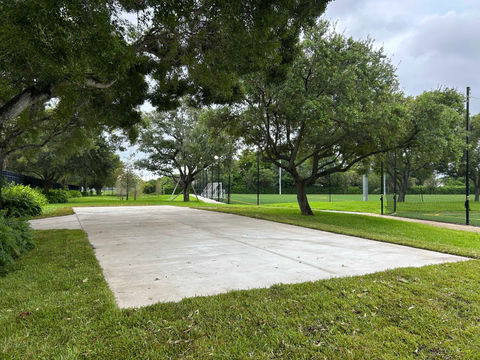 Outdoor concrete pad surrounded by grass and trees
