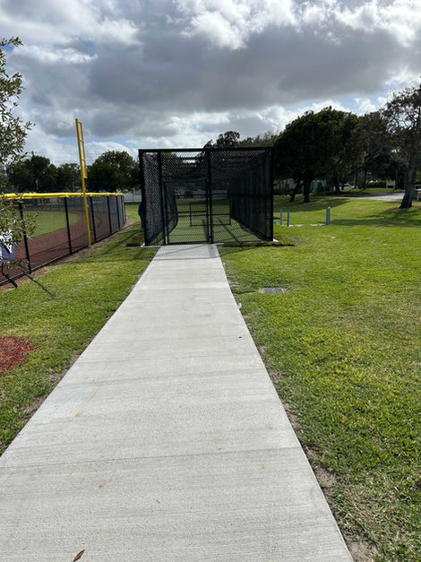 Concrete path leading to a batting cage
