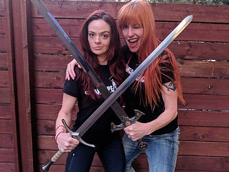 two stage teachers posing with swords