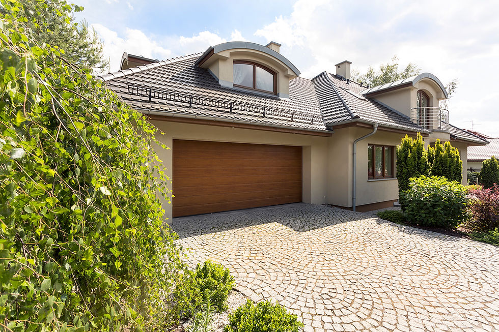 Modern home with a wooden garage door and stone driveway.