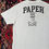 Thumbnail: Back of T-shirt displaying PAPER graphic design