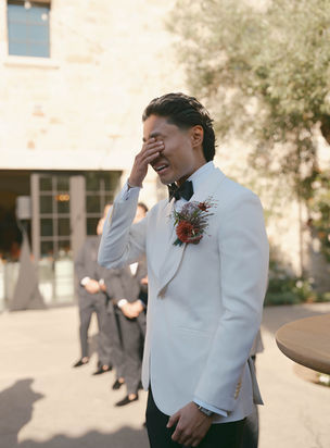 Groom wiping away tears while seeing his bride for the first time during the ceremony at Monserate Winery.