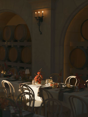 Romantic reception dinner tables with sculptural coral florals and candlelight inside Monserate Winery’s barrel room.