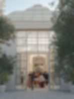 Guests entering the glass conservatory at Luna Escondida, framed by olive trees and the geometric lines of the structure’s grand entrance.