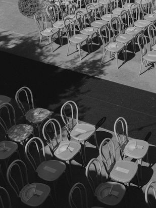 Rows of bentwood chairs arranged for the ceremony at Monserate Winery captured in soft black-and-white tones.