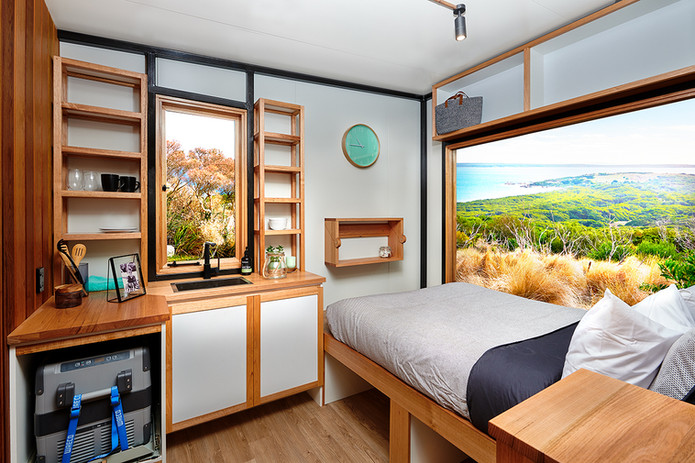 bedding in tiny house with pullout fridge