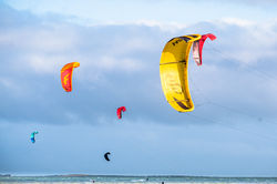lever de soleil, ciel orangé, silhouettes noires de pêcheurs et phare photographe l'œil du Moineau