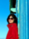 jeune femme brune en rouge cabane bleue ciel bleu