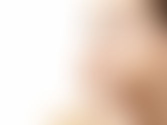 Woman with light skin gazing upward, hands on face, in a serene expression. Background is plain white, emphasizing her thoughtful mood.