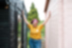 Claire from Copper Knobs Interiors posing between 2 sheds, smiling