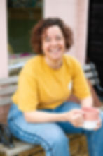 Claire from Copper Knobs Interiors sitting with a mug of tea, smiling to camera