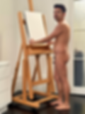 Nude artist posing with an easel in front of him