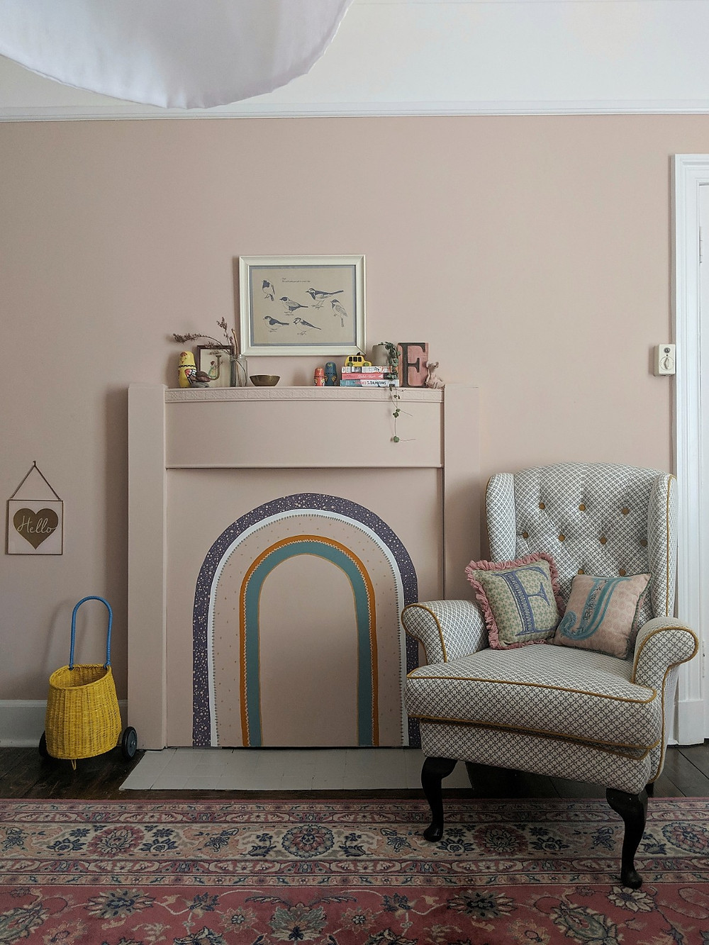 Girls bedroom fireplace painted pink with a rainbow