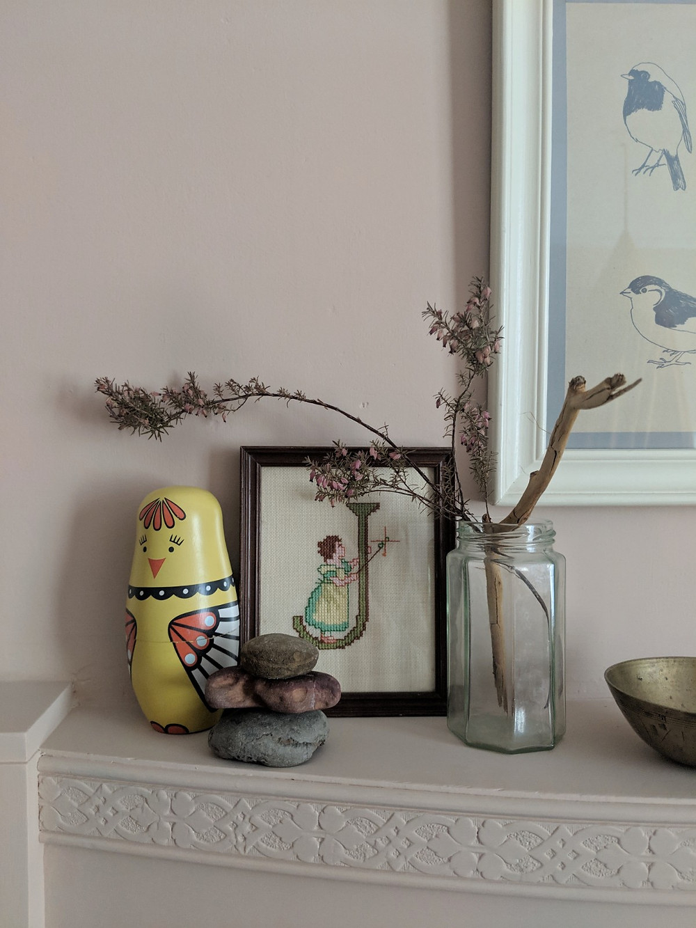 Children's treasures arranged on a pink mantelpiece