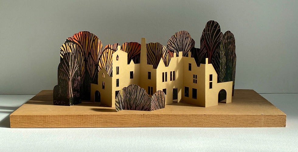 Miniature folding sculpture of Hebden Bridge town and Autumn woodland made from woodcut printing on card.