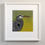 Thumbnail: Framed print of grey heron on green ground. Pale cream frame.