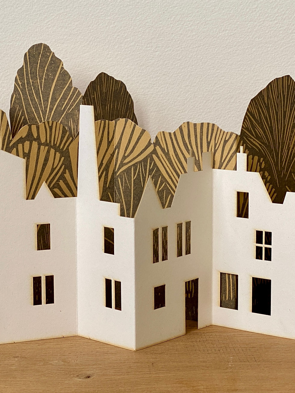 A white paper townscape against grey woodland.