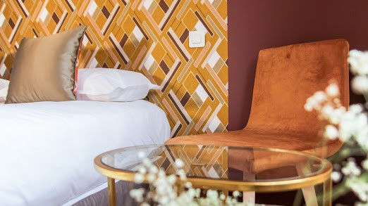 Chambre avec fauteuil en velours et table basse, Hôtel Le Petit Périer à Laval