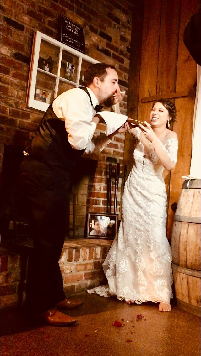 Bride smashing wedding cake in Grooms face