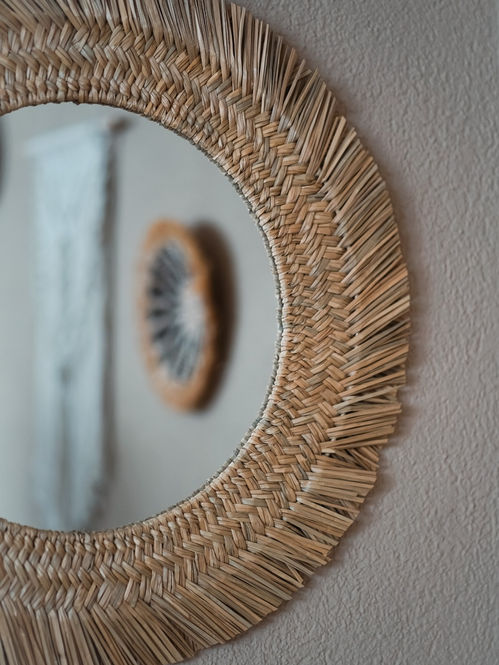 Detailaufnahme eines runden Spiegels aus Naturmaterialien im Praxisraum von Soulissa.