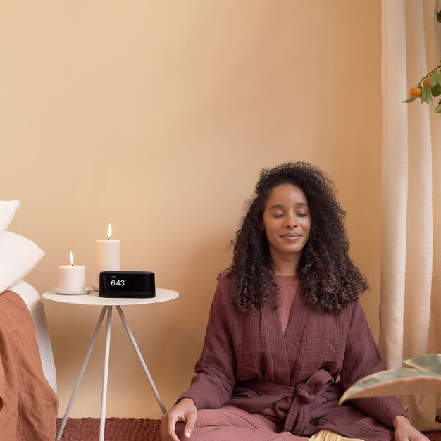 A woman meditating to sounds on the loftie alarm clock for A Self-Improvment Guide | Gifting Yourself