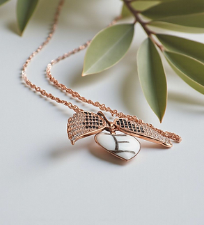 beweglicher engelsflügel mit einem weissen Herz und einem Haar buchstaben | Muttermilchschmuck Schweiz