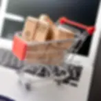 a shopping cart filled with shipping boxes on a laptop symbolizing online shopping and ecommerce services for small business, sell your products online with our ecommerce websites