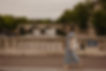 Fota da Mel Rolan caminhando sobre uma ponte em Paris.