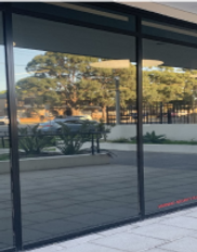 Vista desde afuera de ventanas con vinilo espejado, que hace un reflejo exacto del afuera sin dejar ver el interior