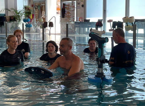 People participating in an aquatic physical therapy session.