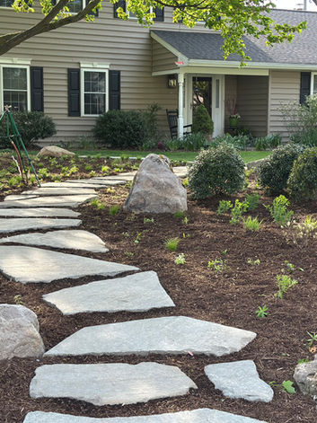 Flagstone pathway leading to a house with landscaping