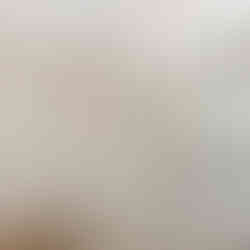 Finished bathroom with a white tub-shower surround and brushed-nickel fixtures, a toilet beside the tub, and a long vanity with an integrated sink, large wall mirror, and multi-light vanity fixture, with closet and door reflected in the mirror.