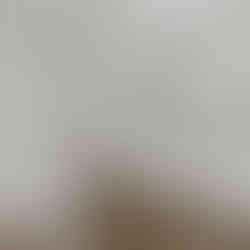 Finished bathroom. There is a white bathtub and shower combo on the left side with a chrome showerhead. There is a white vanity with a double sink, and light wood cabinets. Above the vanity is a large mirror, and a towel bar is visible to the side. The floor is a dark hardwood flooring, and the walls are painted white.