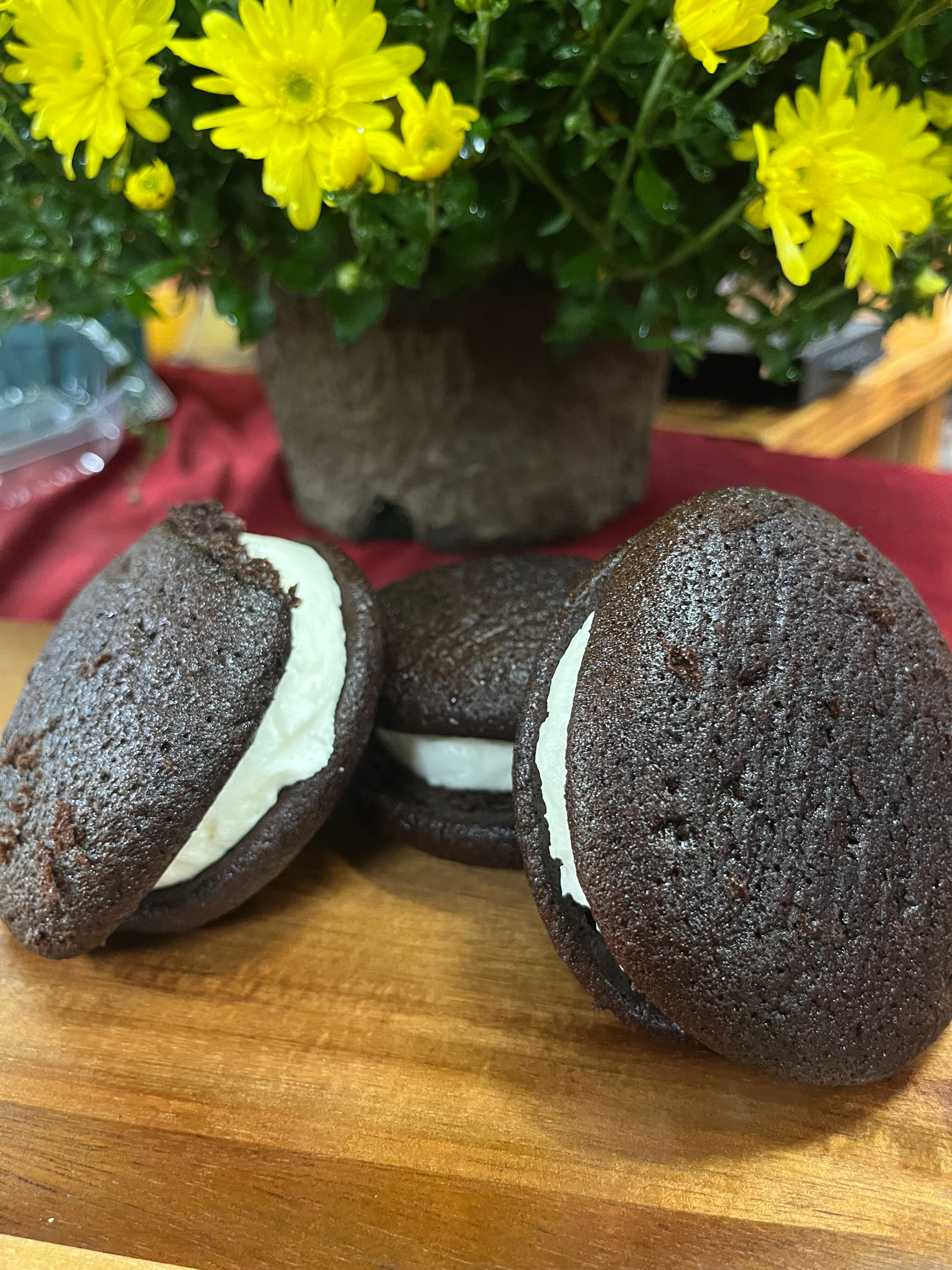 Three chocolate whoopie pies with cream filling Wholesale Snickerdoodle Flavor Explosion Pretzels on display.