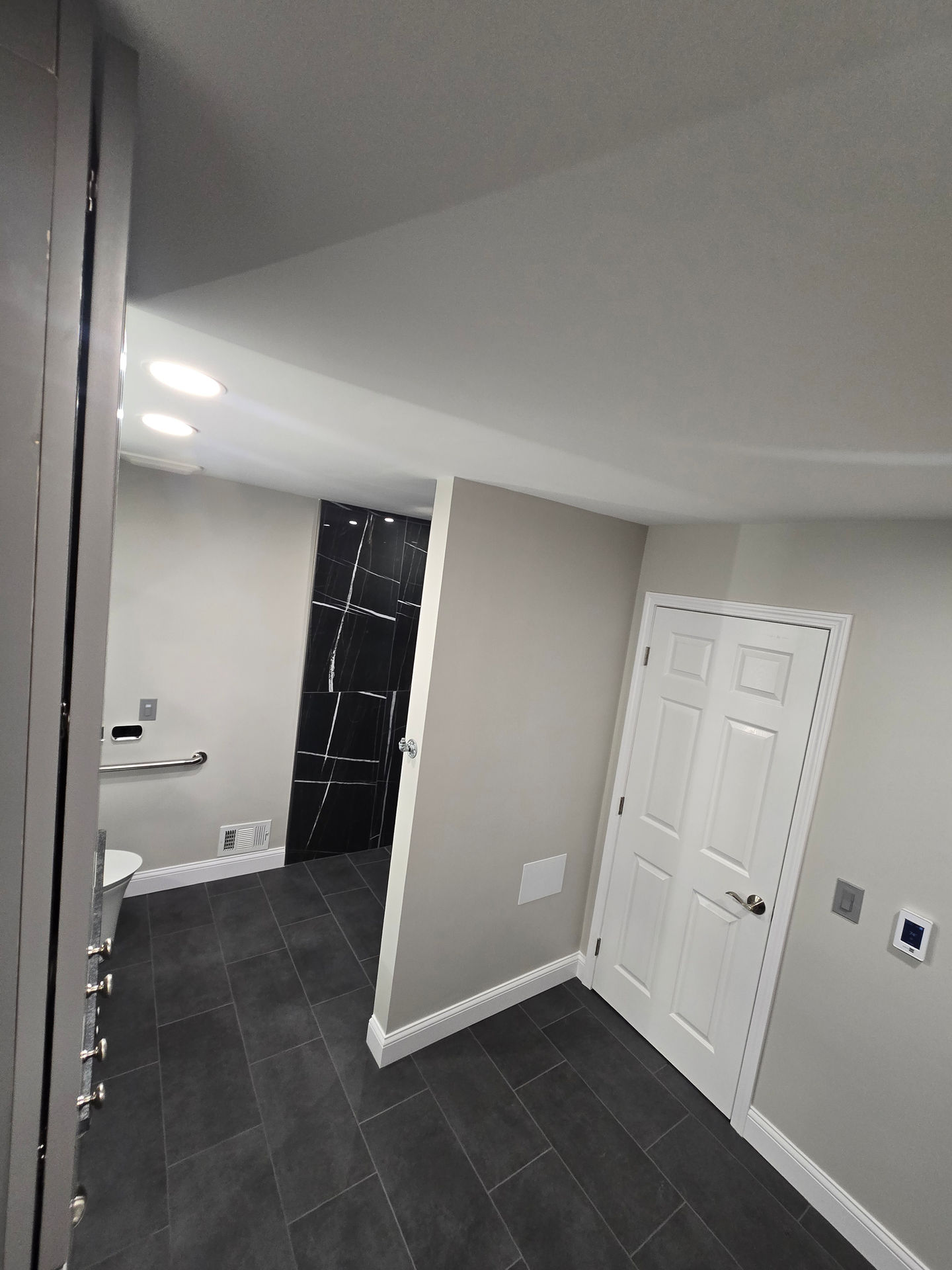 Multi-functional bathroom and laundry room remodel in Livingston County with gray cabinetry and washer-dryer combo