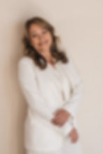 Trisa Tyler Licensed Medicare Advisor in a white suit leaning against a wall