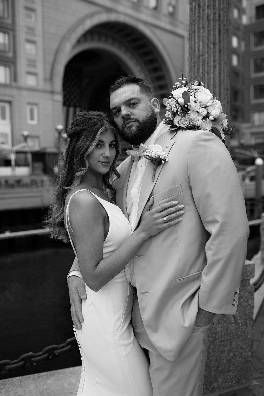 bride and groom take portraits outside a hotel for their boston boat wedding