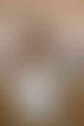 A bride and groom sit at a small table set for dinner. The bride is wearing a white dress, and the groom has a light-colored suit. A "Valiant" sign is displayed in the background.