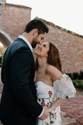 A couple, dressed in formal attire, holds hands for their engagement photos in winter park