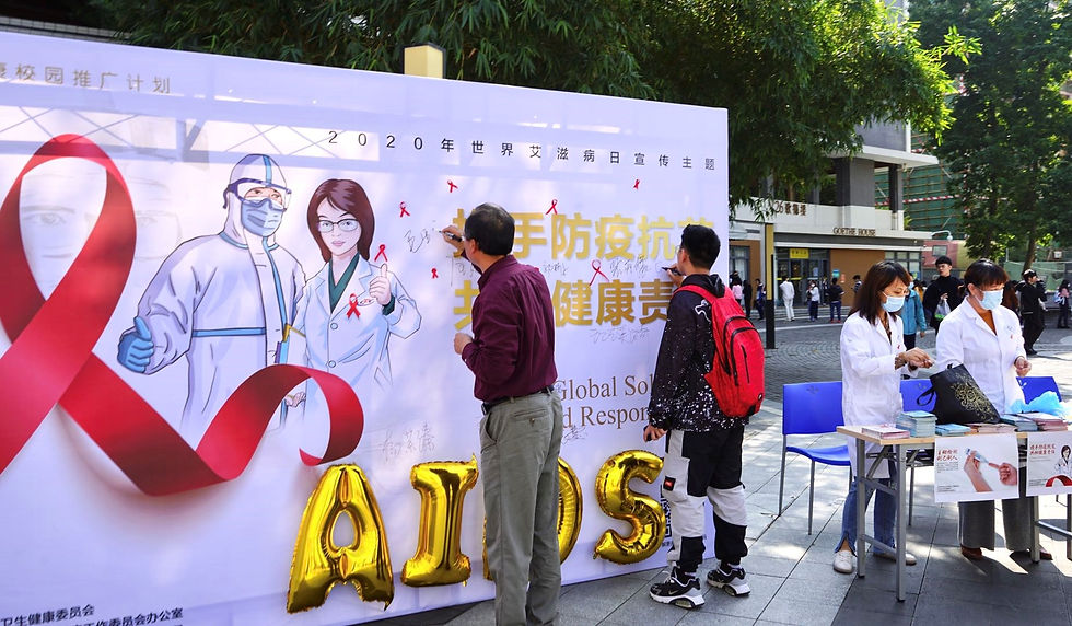 Vice President MAO Yaqing and a volunteer student sign their names on the signed edition of the AIDS awareness campaign on November 30, 2020.
