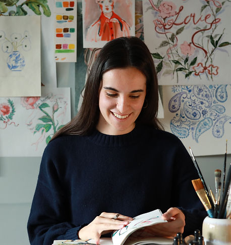 Artist sitting at her desk in her creative studio