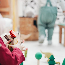 child-in-red-top-holding-wooden-toys-366