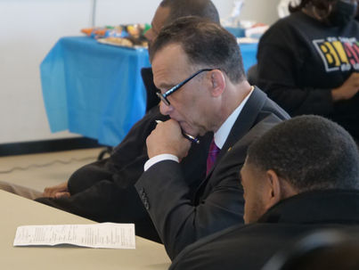 Judge Sugarmon looking down, focused, at a meeting table