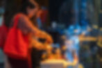 Guest serving food from a buffet table at a lively indoor event with warm lighting
