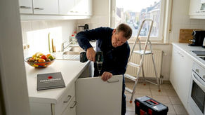 Handyman repairing kitchen cabinet in Tervuren