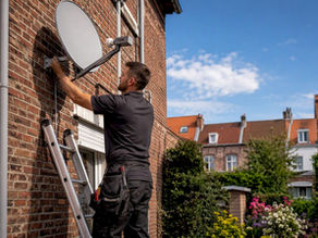 Satellite dish installed on rear residential wall