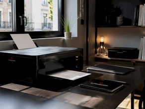 Home printer setup on desk with Eutradesmen logo